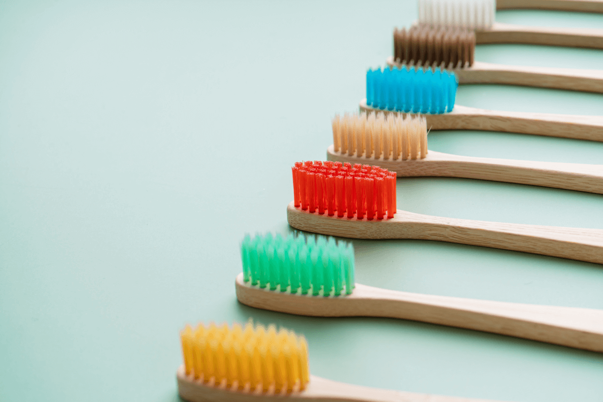 The Ultimate Guide to Sustainable Toothbrushes: Benefits, Options, and Why MABLE Brush is the Best Choice, a series of bamboo toothbrushes on a mint green background