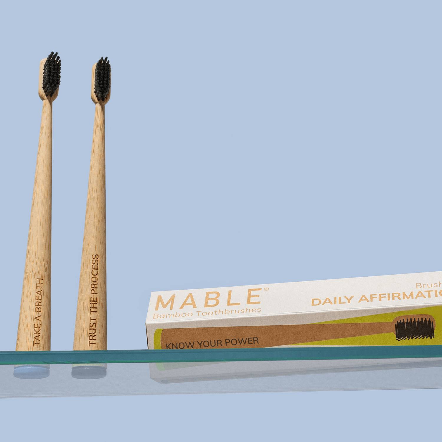 MABLE Affirmation Toothbrush Four Pack, Daily Affirmation Toothbrushes for self-care, Soft bristle natural toothbrush pictured on a glass bathroom shelf, self-standing toothbrushes